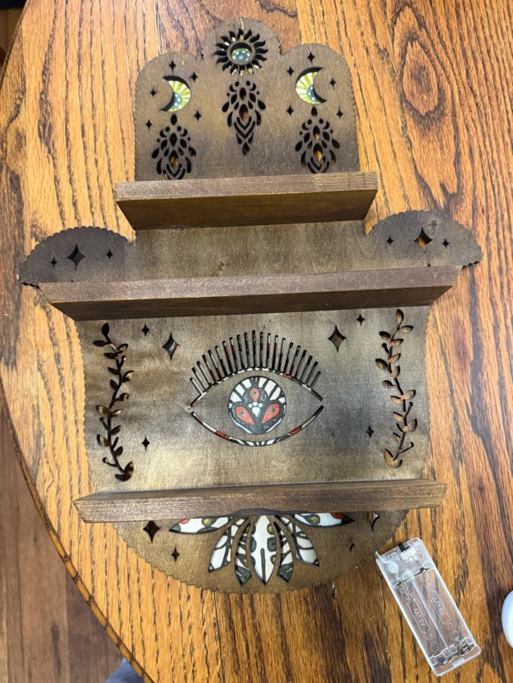 Handcrafted Brown Wooden Wall Shelf with Decorative Eye Motif that lights up